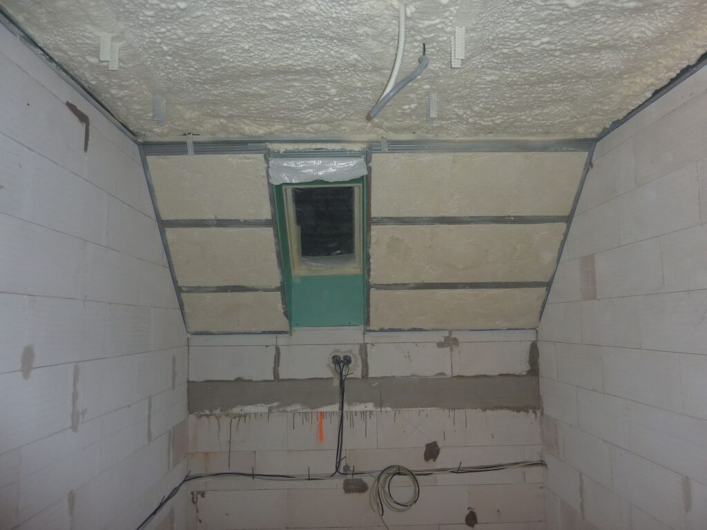 Nastriekaná mäkká PUR pena rozšírená na vnútorný povrch steny.